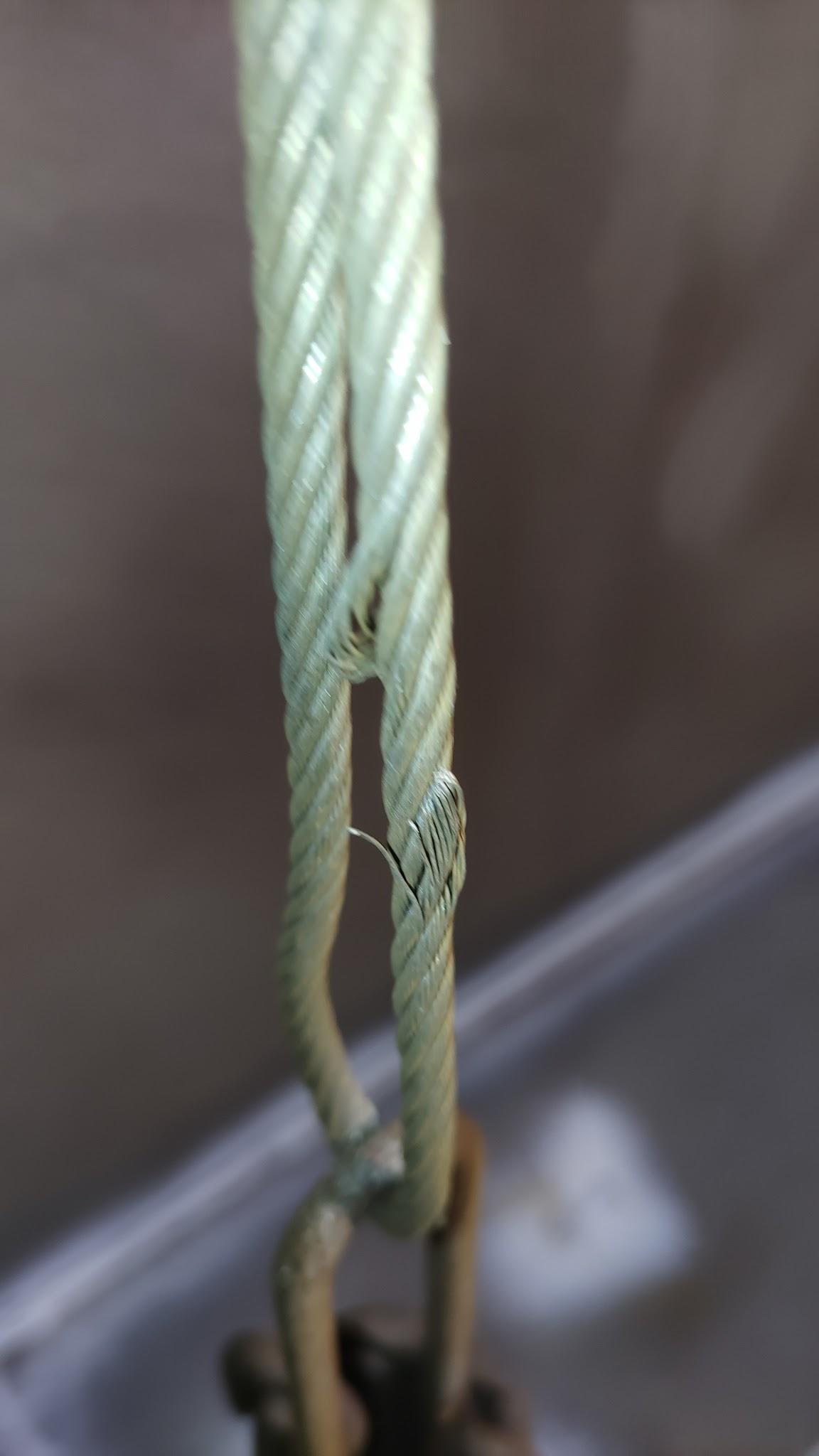Frayed anti-rotation cable illustrating structural restraint failure on an internal floating roof