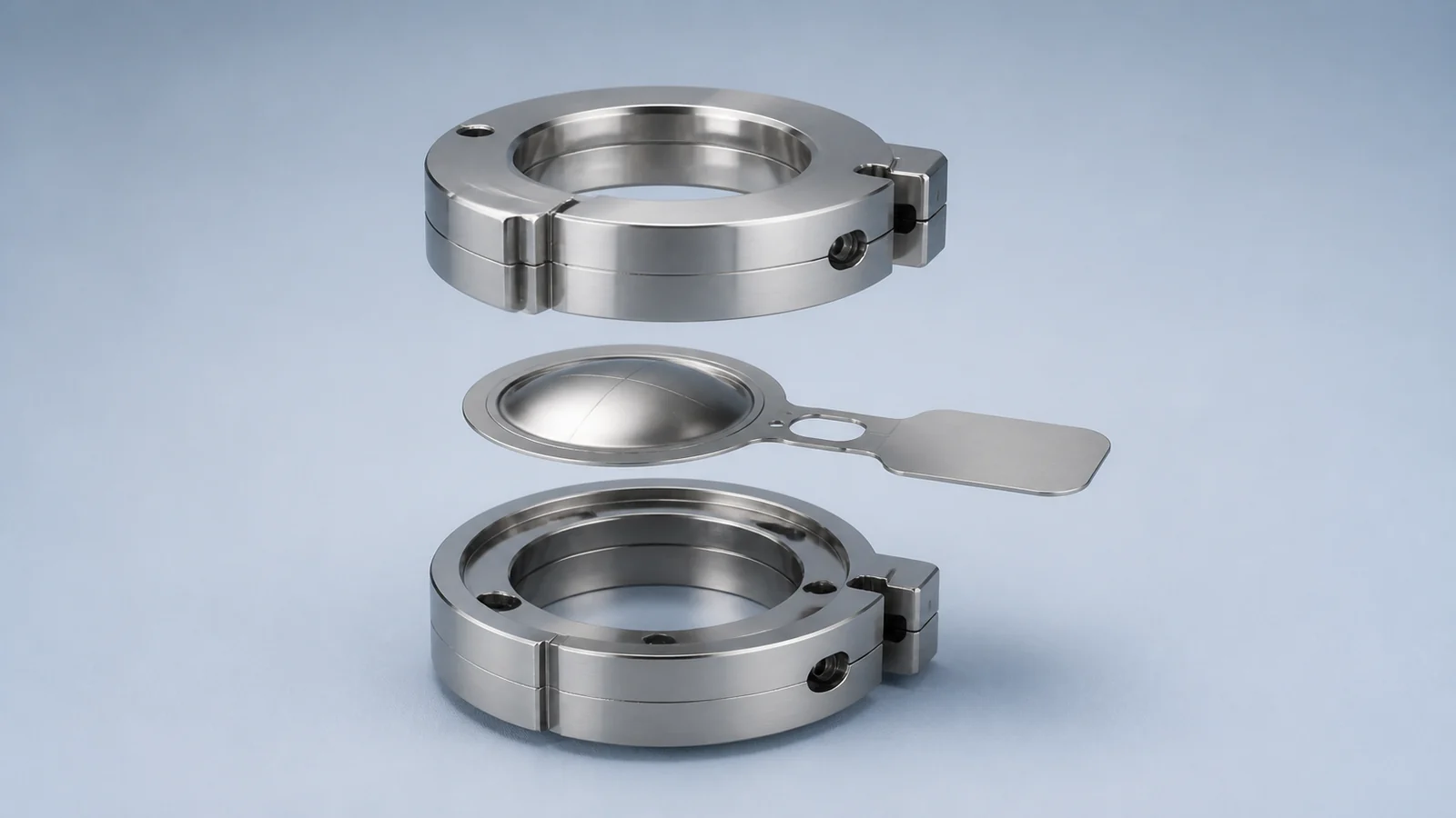 Exploded view of a domed rupture disc positioned between the two halves of its holder